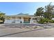 Exterior of community clubhouse with covered porch, lush landscaping, and palm trees under a blue sky at 7532 Marsh Orchid Cir # 8-201, Bradenton, FL 34203
