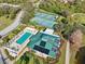 Aerial view showcasing a vibrant community pool, clubhouse, and tennis courts at 7532 Marsh Orchid Cir # 8-201, Bradenton, FL 34203