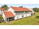 Exterior view of a two-story home featuring a screened-in porch and balcony with red tile roof at 7532 Marsh Orchid Cir # 8-201, Bradenton, FL 34203