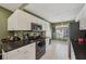 Well-lit kitchen with green walls featuring white cabinetry, granite countertops and stainless steel appliances at 7532 Marsh Orchid Cir # 8-201, Bradenton, FL 34203