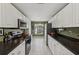 Well-lit kitchen with long granite countertops, white cabinets and stainless steel appliances at 7532 Marsh Orchid Cir # 8-201, Bradenton, FL 34203
