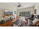 Open living room boasts hardwood floors, a ceiling fan, and sliding doors leading to a balcony at 7532 Marsh Orchid Cir # 8-201, Bradenton, FL 34203