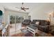 Bright living room features hardwood floors, ceiling fan, and sliding doors to a balcony at 7532 Marsh Orchid Cir # 8-201, Bradenton, FL 34203