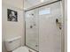 Modern shower with glass door, white tile, black and white floor and a small upper window at 7532 Marsh Orchid Cir # 8-201, Bradenton, FL 34203