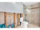 Bathroom featuring tiled shower with glass door, toilet, and exposed pipes at 8421 Flagstone Dr, Tampa, FL 33615