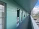 Exterior hallway with light green walls and several apartment doors visible at 2042 Australia W Way # 74, Clearwater, FL 33763