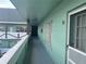 Exterior hallway with a light green wall and a number of apartment doors at 2042 Australia W Way # 74, Clearwater, FL 33763