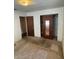 Bedroom with a closet with mirrored doors, a ceiling light, and worn carpeting at 10120 N Aster Ave, Tampa, FL 33612