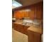 This kitchen features wood cabinets, butcher block countertops and a stainless-steel sink at 10120 N Aster Ave, Tampa, FL 33612