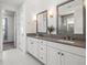 Bathroom featuring double sink vanity, large mirrors, modern lighting, and tiled floors at 1021 Seagrape Dr, Ruskin, FL 33570