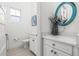 Stylish half bathroom with a decorative mirror, modern vanity, white cabinetry, and neutral decor at 1021 Seagrape Dr, Ruskin, FL 33570