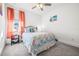 Charming bedroom featuring a cozy bed with coral-themed bedding, side table, and bright window at 1021 Seagrape Dr, Ruskin, FL 33570