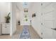 Bright entryway features light gray plank flooring, white walls, accent table and art at 1021 Seagrape Dr, Ruskin, FL 33570