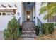 Inviting entryway with decorative glass front door, brick steps, potted plants, and pergola over the garage at 1021 Seagrape Dr, Ruskin, FL 33570