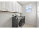 Laundry room with cabinets, front-load washer and dryer, and a window at 1021 Seagrape Dr, Ruskin, FL 33570