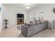 Inviting living room with a large gray sofa, stylish rug, and ample natural light from shuttered windows at 1021 Seagrape Dr, Ruskin, FL 33570