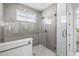 Shower room featuring glass doors, shower head, and a window at 1021 Seagrape Dr, Ruskin, FL 33570