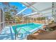 Inviting screened-in pool area with lounge chairs, perfect for sunny relaxation at 10261 Horizon Dr, Spring Hill, FL 34608