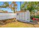 White storage shed with a window, gray trim, and landscaping in a fenced backyard at 10261 Horizon Dr, Spring Hill, FL 34608