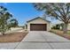 Beige house with brown garage door, driveway, and landscaping at 11206 Silver Fern Way, Riverview, FL 33569