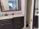 Bathroom with a dark wood vanity, granite countertops, and a large mirror for grooming ease at 12368 70Th St, Largo, FL 33773