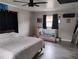 View of the bedroom showcasing gray wood-look flooring, modern ceiling fan, and natural light at 12368 70Th St, Largo, FL 33773