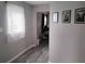 View of the hallway featuring a window with white curtain and gray wood-look flooring at 12368 70Th St, Largo, FL 33773