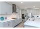 Well-lit kitchen with gray cabinets, stainless steel appliances, and a white countertop island featuring a sink and modern faucet at 12625 Horseshoe Bend Dr, Lithia, FL 33547