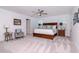 Bright main bedroom featuring a king-size bed, two windows and soft, patterned carpeting at 12625 Horseshoe Bend Dr, Lithia, FL 33547