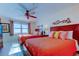 Bright bedroom featuring two beds with colorful bedding, a ceiling fan, and a window with a view at 13500 Gulf Blvd # 702, Madeira Beach, FL 33708