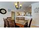 Bright dining area featuring a glass-top table, stylish chandelier, and an open view into the well-lit kitchen at 13500 Gulf Blvd # 702, Madeira Beach, FL 33708