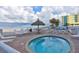 Hot tub spa with comfortable seating areas, umbrellas, and beachfront access at 13500 Gulf Blvd # 702, Madeira Beach, FL 33708