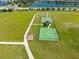 An aerial view of community basketball courts surrounded by green space and walkways by a lake at 13526 Palmera Vista Dr, Riverview, FL 33579