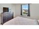 Bedroom featuring a dark wood dresser, mounted TV and a bright window with neighborhood views at 13526 Palmera Vista Dr, Riverview, FL 33579