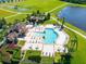 Aerial view of a resort-style community pool with ample seating, lush landscaping, and nearby amenities at 13526 Palmera Vista Dr, Riverview, FL 33579