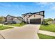 Attractive home features a manicured lawn, a two car garage, and a modern white and black facade at 13526 Palmera Vista Dr, Riverview, FL 33579