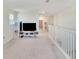 Loft area featuring TV and staircase with white railing at 13526 Palmera Vista Dr, Riverview, FL 33579