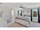 Bright main bedroom featuring a ceiling fan, bedside tables, and an ensuite bath at 13526 Palmera Vista Dr, Riverview, FL 33579