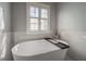 Luxurious soaking tub with modern fixtures, set against shuttered windows, for relaxation at 1442 Harbour Walk Rd, Tampa, FL 33602