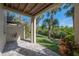 Relaxing covered patio featuring pavers, a view of well-maintained lawn and tropical palm trees at 1442 Harbour Walk Rd, Tampa, FL 33602