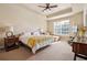 Bright bedroom featuring a trey ceiling, ceiling fan, large window, and seating area at 14543 Mirabelle Vista Cir, Tampa, FL 33626