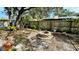 Fenced-in backyard featuring a charming stone fire pit, perfect for outdoor gatherings and relaxation at 1670 Monterey Dr, Clearwater, FL 33756