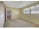 Simple bedroom featuring light-yellow walls, carpet flooring, and a large closet at 2054 Envoy Ct, Clearwater, FL 33764