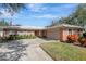 Brick ranch home with a large driveway and mature landscaping at 2054 Envoy Ct, Clearwater, FL 33764