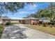 Brick ranch home with a large driveway and mature landscaping at 2054 Envoy Ct, Clearwater, FL 33764