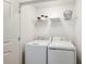 Convenient laundry room with washer, dryer, and shelving for storage at 2075 Hallier Cv, Wesley Chapel, FL 33543