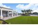 Poolside lounge area with a pergola, BBQ, dining area, and palm trees at 2101 Hallier Cv, Wesley Chapel, FL 33543