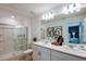 Bright bathroom featuring double sinks, white cabinets, and a glass-enclosed shower at 2127 Hallier Cv, Wesley Chapel, FL 33543