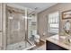 Well-lit bathroom featuring a glass-enclosed shower, toilet, vanity, and a decorative framed art at 24121 Landing Dr, Lutz, FL 33559