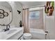 Contemporary bathroom featuring sleek fixtures, decorative shelves, and a bathtub with tile surround at 24121 Landing Dr, Lutz, FL 33559